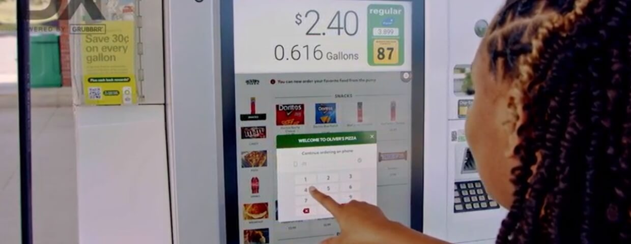 Woman using touch screen gas pump