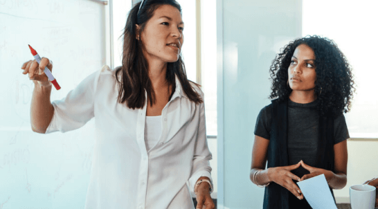 Woman presenting from whiteboard