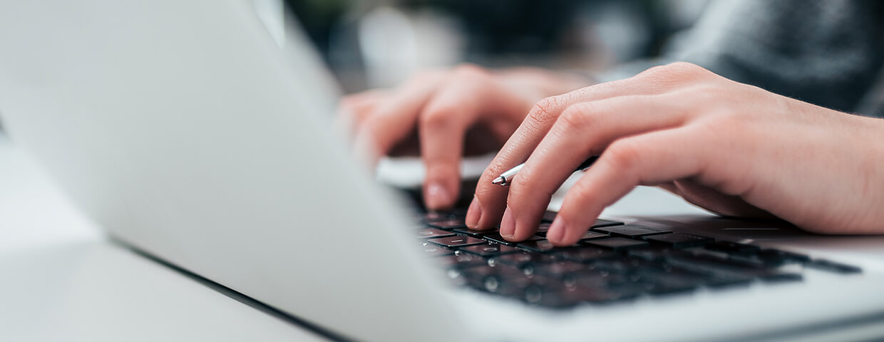 Person's hands typing on laptop