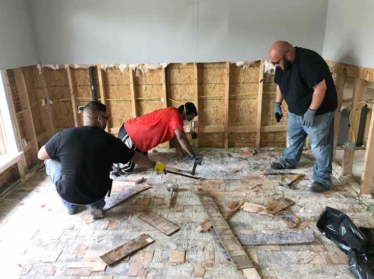 Dover employees assisting with repairs to a damaged home