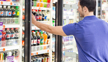 Man choosing drink from cooler case