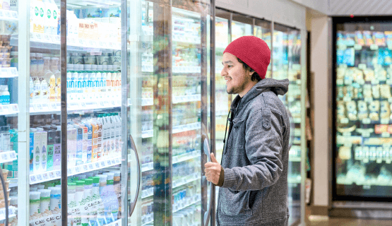 Woman browsing case of groceries